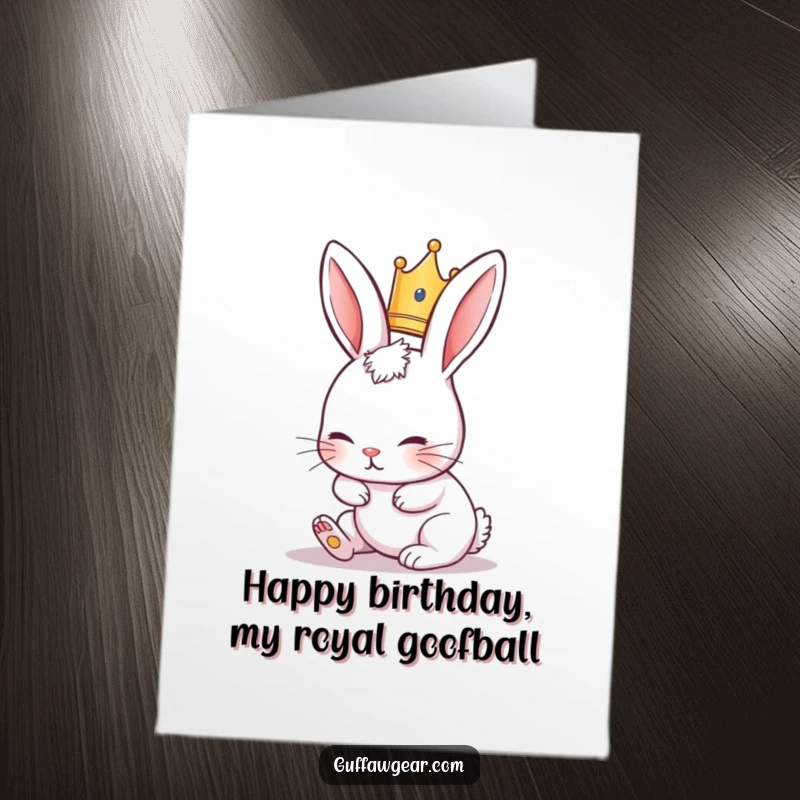 Funny free printable birthday card: a rabbit wearing a tiny crown trips hilariously over its own long ears, a royal mishap.