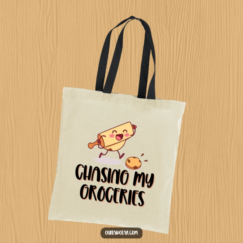 Funny tote bag with a rolling pin character chasing a cookie, ideal for carrying baking items with humorous flair.